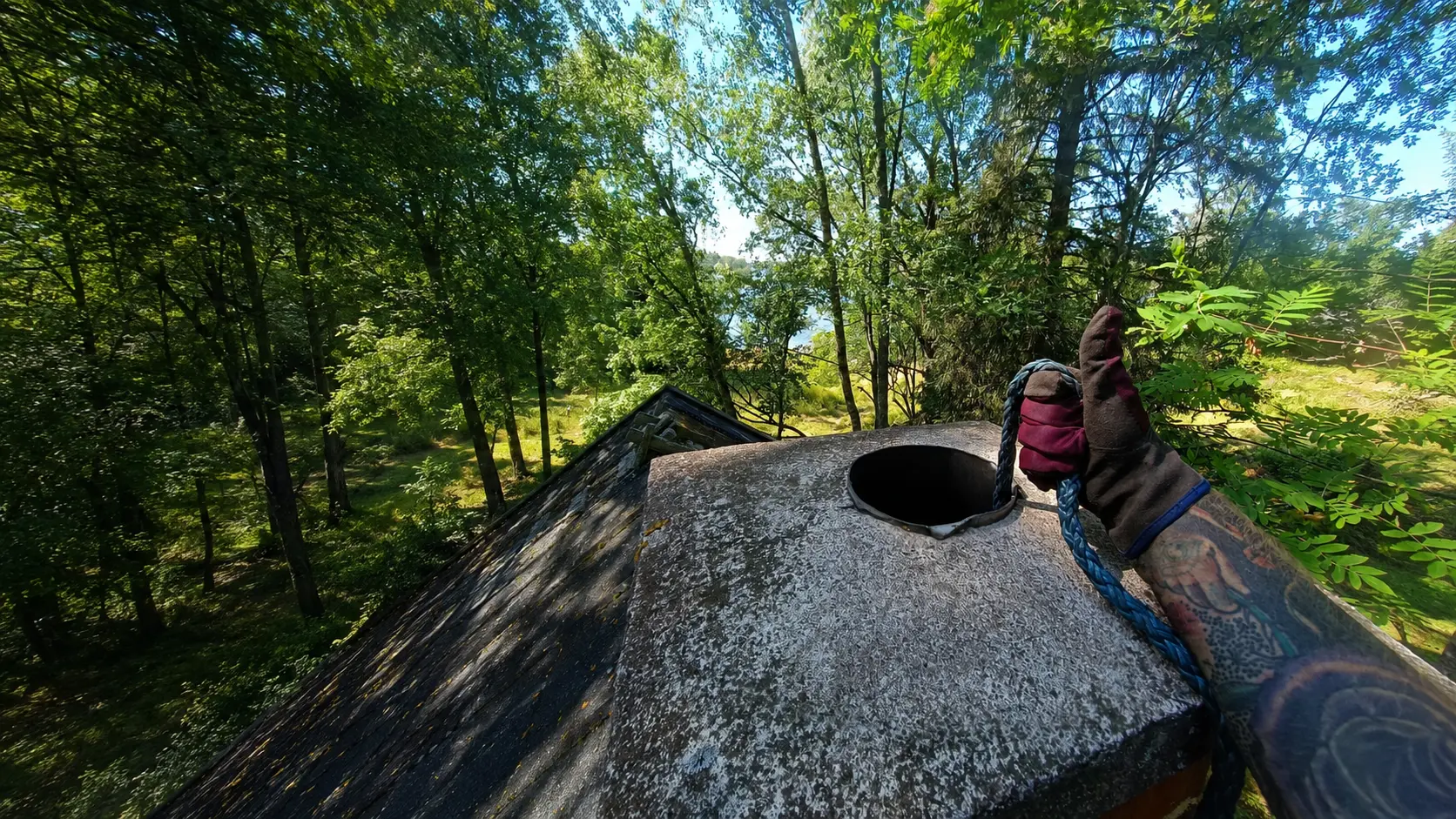 Nuohooja työssä katolla, laaja maisemakuva