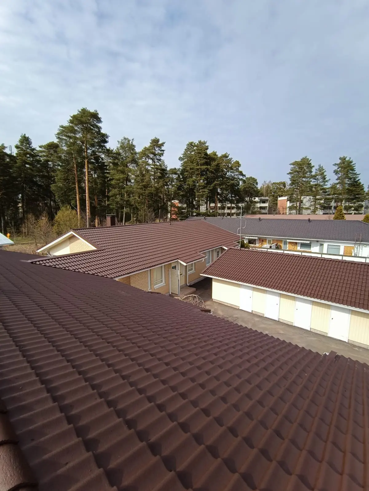 Taloyhtiön ruskea tiilikatto pinnoitettuna